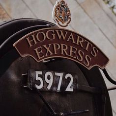 the hogwart's express sign is on top of an old fashioned train car