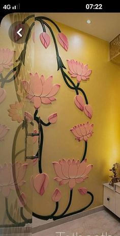 a bathroom with yellow walls and pink flowers painted on the glass wall next to it