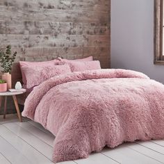 a bed with pink comforters and pillows