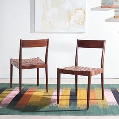 two chairs sitting next to each other on a rug