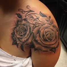 a woman's chest with roses on it and the word love written in cursive writing