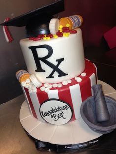 a graduation cake with the letters r and x on it, sitting on top of a table