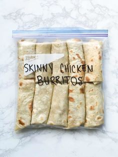 skinnyy chicken burritos wrapped in plastic on a marble countertop with the words skinnyy chicken burritos printed on it