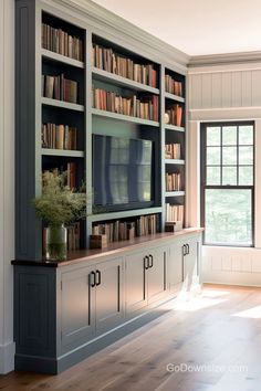 a living room with bookshelves and a television on the wall in front of it