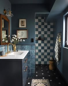 a bathroom with blue walls, black and white checkerboard flooring and a rug on the floor