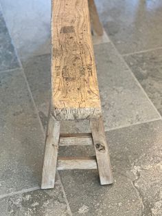 a wooden bench sitting on top of a tiled floor