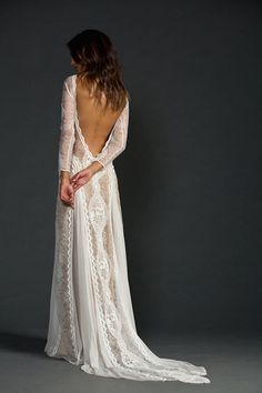 the back of a woman's wedding dress, with long sleeves and lace detailing