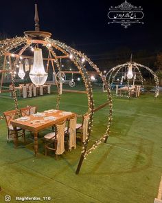 an outdoor dining area is decorated with string lights and chandeliers