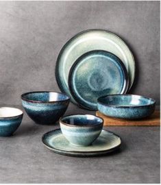 a blue and white dinnerware set on a wooden table with grey background in the middle