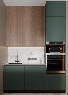 a modern kitchen with green cabinets and marble counter tops is pictured in this image, there are two ovens next to the sink