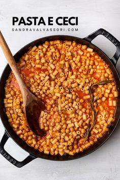 pasta e ceci in a skillet with a wooden spoon on the side and text overlay that reads, pasta e ceci