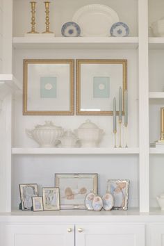 a white shelf with pictures and other items on it