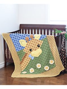 a crib bed with a giraffe quilt on it