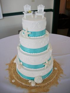 a white and blue wedding cake with chairs on top