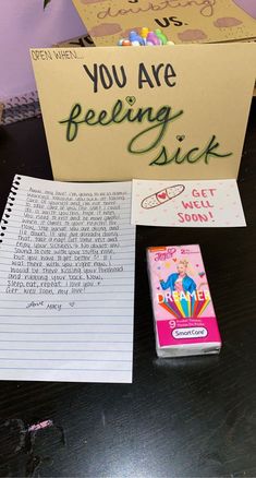 a notepad, pen and sticky pad sitting on a desk next to a sign that says you are feeling sick