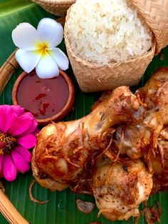 some food is sitting on a plate with flowers and sauces in the bowl next to it