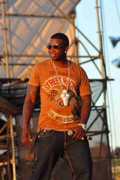 a man standing on top of a skateboard in front of a stage wearing sunglasses