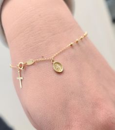 Elevate your faith-inspired style with our Rosary Bracelet featuring a Dangling Miraculous and Cross. Crafted with precision in solid 14K yellow gold, this bracelet exudes elegance and devotion. The delicate beads, each measuring 1.5mm, symbolize prayers and devotion, while the Miraculous medal (8x6mm) and cross (10x6mm) add a touch of sacred beauty. With a comfortable 7-inch length, this bracelet is a timeless expression of faith and grace, perfect for daily wear or special occasions. Details: Rosary Bracelet, Miraculous Medal, Yellow Gold Bracelet, Rosary, Daily Wear, Gold Bracelet, Yellow Gold, Bracelet, Beads