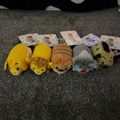 five stuffed animals are lined up on the floor