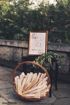 a basket filled with books sitting on top of a stone floor next to a sign