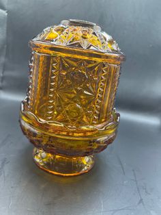 a yellow glass vase sitting on top of a table