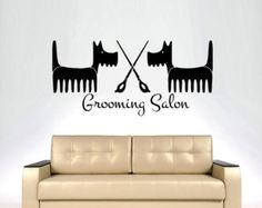 a living room with a couch and wall decal that says grooming salon on it