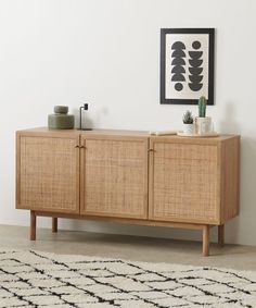 the sideboard is made from rattan and has an open shelf on one side