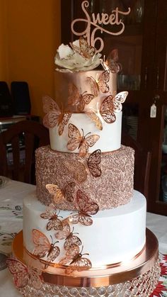 there is a three layer cake with butterflies on it