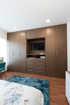 a bedroom with a bed, dresser and television on the wall in front of it