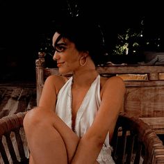 a woman sitting on top of a wooden bench