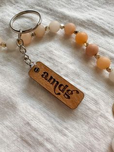 a wooden keychain with beads and an inscription on it that reads, angels