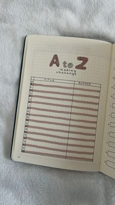 an open notebook with numbers and bars on it sitting on a white blanket next to a cell phone