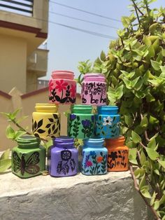 there are many colorful jars sitting on the ledge