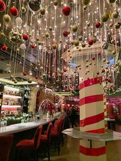 a christmas themed bar with red and white ornaments hanging from the ceiling, decorated with candy canes