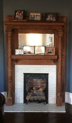 a living room with a fireplace and pictures on the mantle