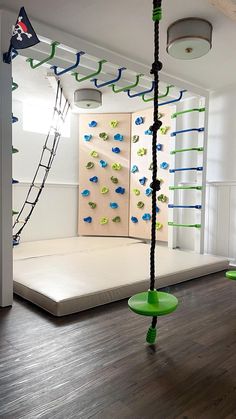 an indoor play area with climbing ropes and green frisbees