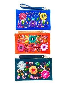 three different colored purses with flowers on them