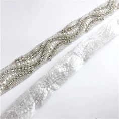 Add a touch of classic elegance to your bridal gown with this sparkling beaded belt! Adorned with an array of glowing crystals and shimmery pearls on a silver base, it will give your dress an extra touch of glam to finish off your perfect look on your wedding day. This appliqué is designed to go seamlessly all around your waist and can be sewn directly onto your dress. The pearl and crystal appliqué measures approx. 36" long (approx. 91.5cm) by 1" wide (approx. 2.5cm). Hypoallergenic - lead, nic Elegant Silver Bridal Belt With Pearl Embroidery, Silver Bridal Belt With Pearl Embroidery, Silver Bridal Belt With Pearl Embroidery For Wedding, Bridal Accessories Belt, Hair Accessories Tiara, Flower Girl Jewelry, Pearl Bridal Jewelry, Rose Gold Bridal, Pearl Jewelry Sets