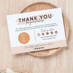 a thank you card sitting on top of a wooden plate