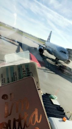 an airplane on the tarmac with writing on it's side and another plane in the background