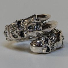 *  Awesome & unusual! Our own design of a dragon claw ring   with skulls running head to head along the ring!*  Hand made in our workshops in Devon*  .925 fully hall marked sterling silver ring*  Available in M - Z*  Special Sizes are available on request Edgy Silver Skull Ring As Gift, Edgy Silver Jewelry For Biker Events, Adjustable Silver Jewelry For Biker Events, Edgy Silver Skull Ring For Gift, Punk Skull Jewelry For Biker Events, Sterling Silver Skull Ring In Punk Style, Edgy Silver Skull Jewelry, Adjustable Silver Skull Ring In Punk Style, Silver Skull Ring In Punk Style