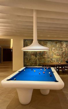 a pool table in the middle of a room with a mural on the wall behind it