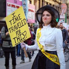 a woman holding a sign that says time traveled for this?