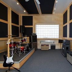 an empty room with guitars, amps and sound equipment