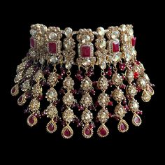 a bunch of red and gold jewelry on a black background