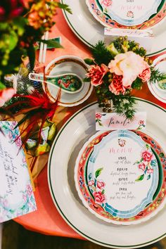 the table is set with colorful plates and place settings for guests to sit down at