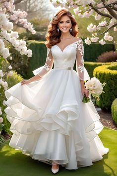 a woman in a white wedding dress standing under a tree with pink flowers on it