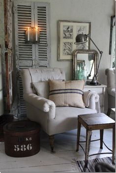 a living room filled with furniture next to a wall covered in pictures and candles on top of it