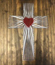 a cross made out of sticks with a red heart on the front and back side