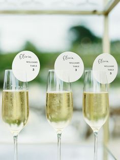 three wine glasses filled with champagne sitting next to each other on top of a table